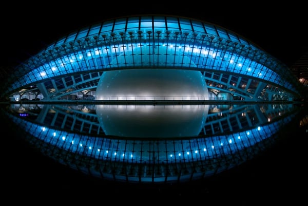 Blue Stadium with a Large Grey Sphere Inside at Night