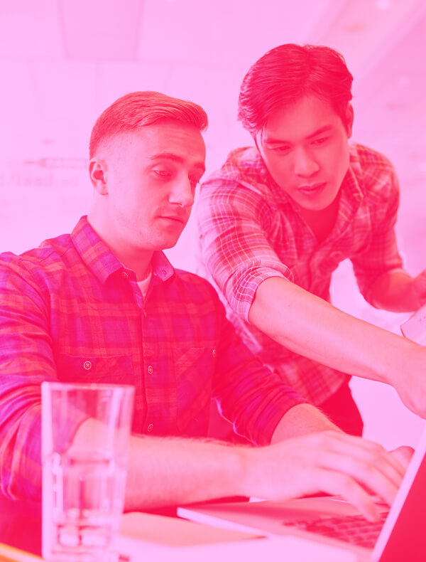 Pink Image of Two Men Working on a Laptop