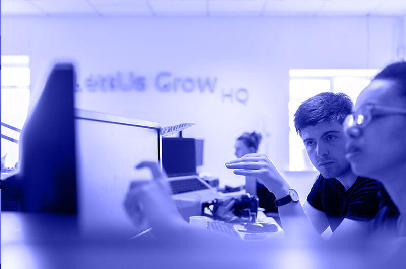 Blue Image of a Man and a Woman Looking at and Touching a Computer Screen