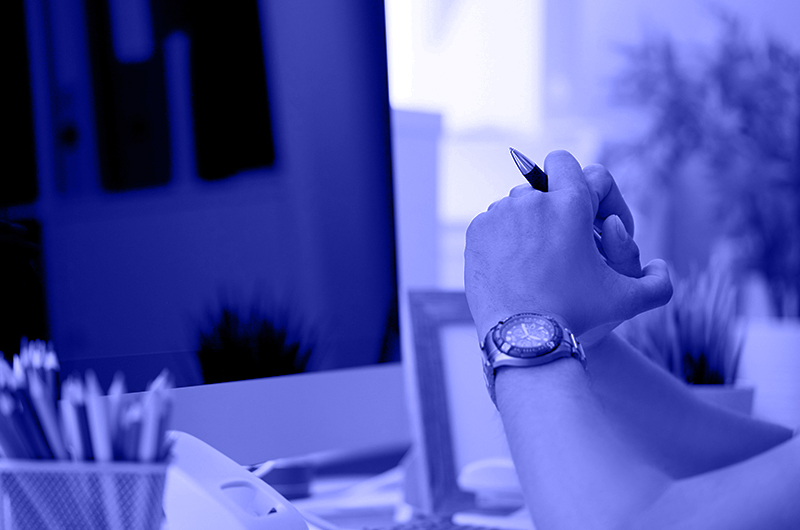 Blue Image of a Person Solving a Problem at a Desk